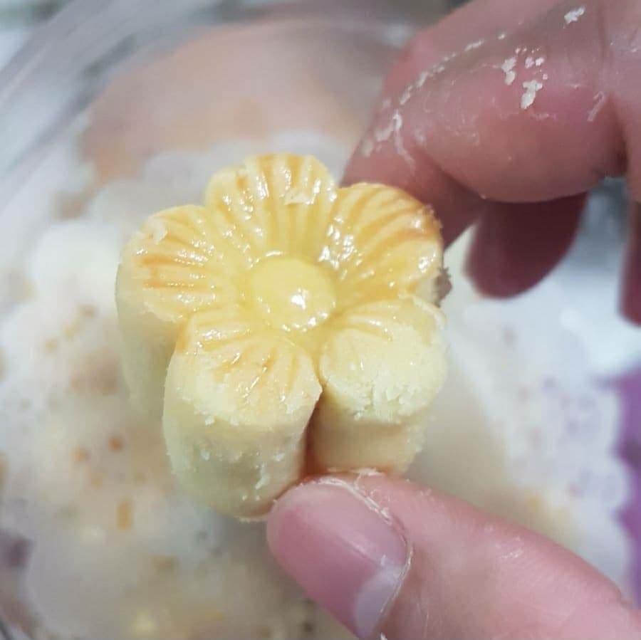 A single flower tart held in a hand